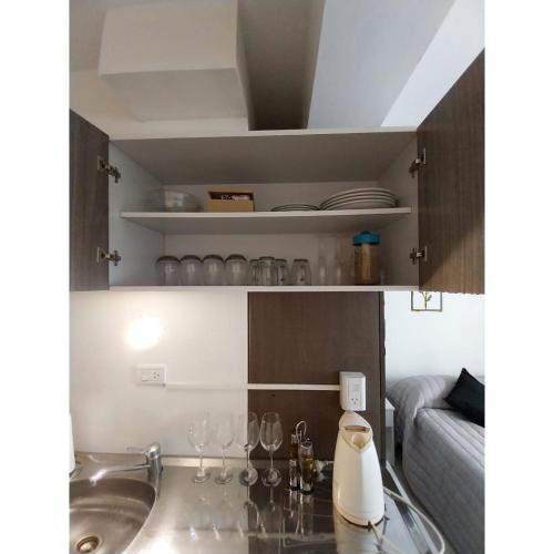a kitchen with a sink and wine glasses on a counter at Shanti Alojamiento Monoambiente y Departamento in Mendoza