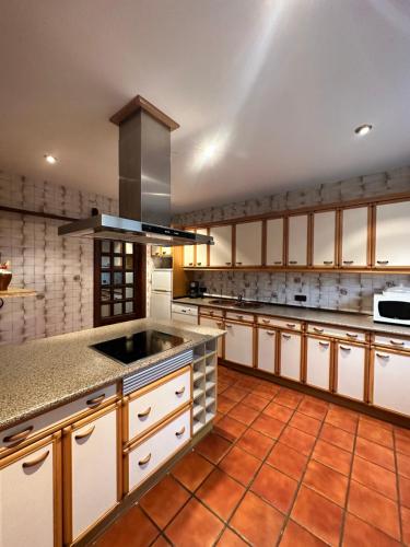 a large kitchen with white cabinets and a sink at Finca Paraíso Rural in El Burgo de Osma