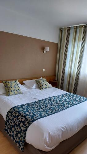 Ένα ή περισσότερα κρεβάτια σε δωμάτιο στο Hôtel Brun