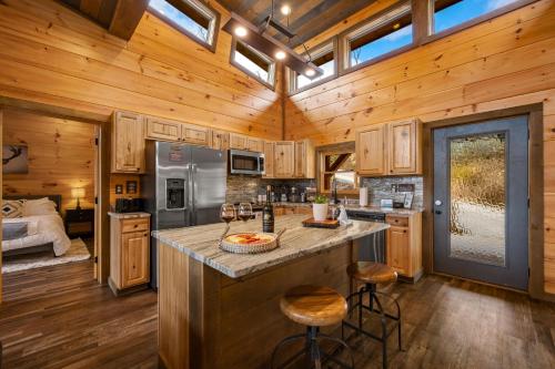 una cocina con armarios de madera y una gran isla en una cabaña en The Overlook - '21 Cabin - Gorgeous Unobstructed Views - Fire Pit Table - GameRm - HotTub - Xbox - Lots of Bears, en Gatlinburg