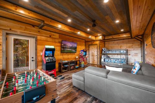 a living room with a couch and a foosball table at The Overlook - '21 Cabin - Gorgeous Unobstructed Views - Fire Pit Table - GameRm - HotTub - Xbox - Lots of Bears in Gatlinburg