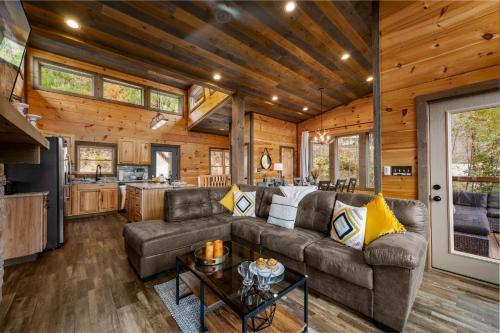 a living room and kitchen in a log cabin at The Overlook - '21 Cabin - Gorgeous Unobstructed Views - Fire Pit Table - GameRm - HotTub - Xbox - Lots of Bears in Gatlinburg