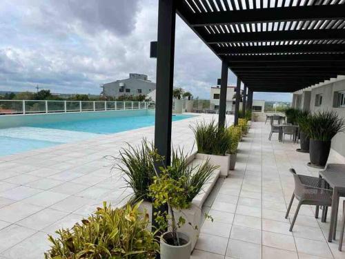 a patio with tables and chairs and a swimming pool at Sky Tower Increíble Departamento en Asunción in Asuncion