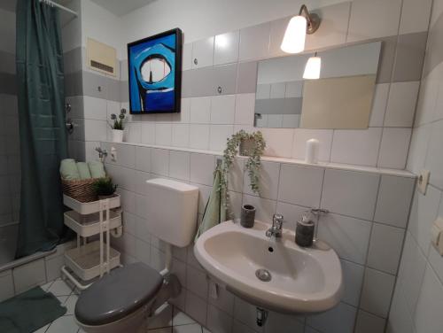 a bathroom with a toilet and a sink at ZEN Apartment - good traffic connection - bright in Karlsruhe