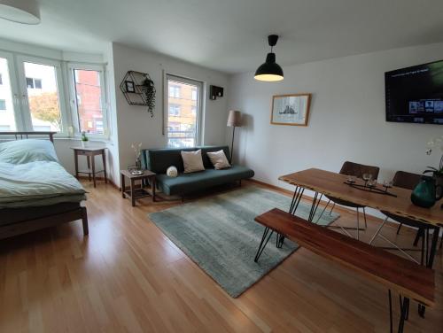 a living room with a couch and a table at ZEN Apartment - good traffic connection - bright in Karlsruhe