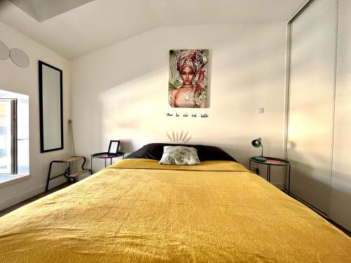 une chambre avec un grand lit avec un couvre-lit jaune dans l'établissement Le Jack' N Klo, accès terrasse de l'établissement, à Rives