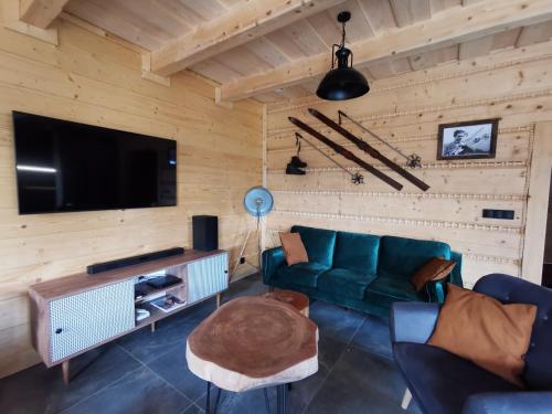 扎沃亞的住宿－Predlówka - Na dachu Świata，客厅配有绿色沙发和平面电视