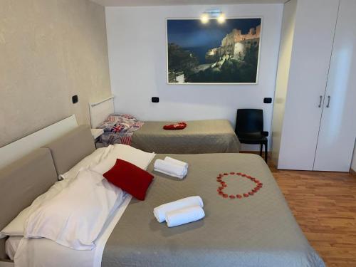 ポリニャーノ・ア・マーレにあるLe Dimore Del Sarto roomsのベッド2台とロースターヤステリヤステリヤステリヤステリヤステリが備わる客室です。