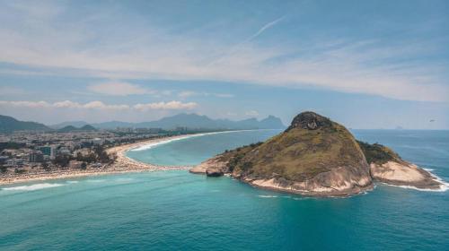 an island in the ocean next to a beach at Longboard Paradise Surf Club in Rio de Janeiro