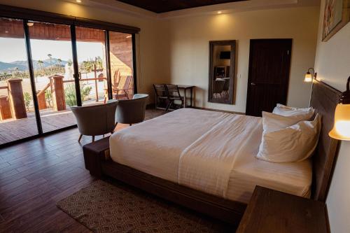 a bedroom with a bed and a view of a balcony at Entrevalle Hotel Boutique in Valle de Guadalupe