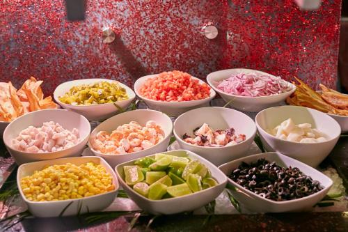 Un grupo de cuencos llenos de diferentes tipos de comida. en Real Intercontinental San Salvador by IHG, en San Salvador