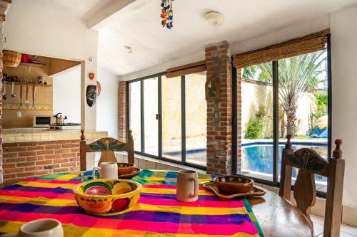 a dining room with a table with a colorful rug at Casa Madero in Oacalco