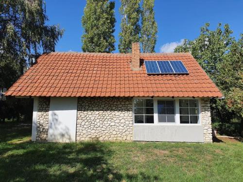 a house with an orange roof with a solar panel on it at Kućerak Višnja in Manđelos