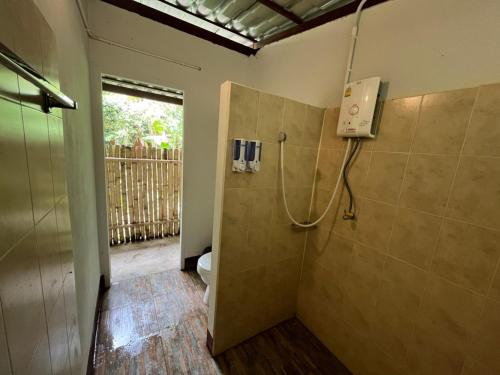 ein Bad mit Dusche, WC und Telefon in der Unterkunft Brown House Chiangdao in Chiang Dao