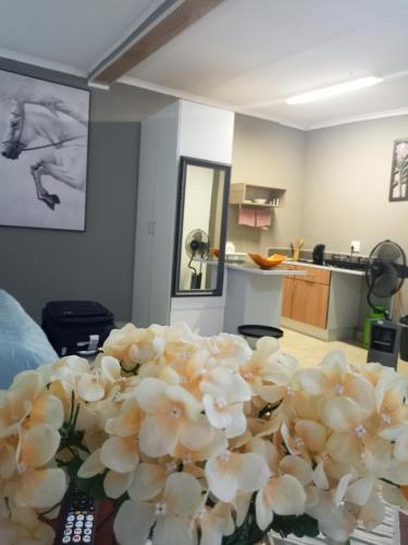 a bunch of flowers sitting on a table in a room at Menlyn Mews Guesthouse in Pretoria