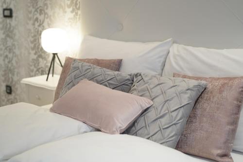 a pile of pillows sitting on top of a bed at ROYAL SUITE, Ljubljana in Ljubljana