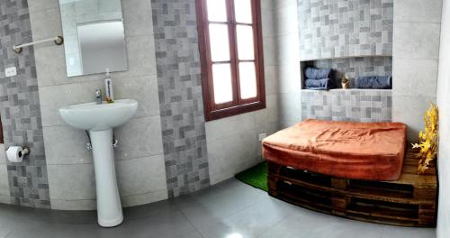 a bathroom with a toilet and a sink and a stool at Minka Hostel in Quito