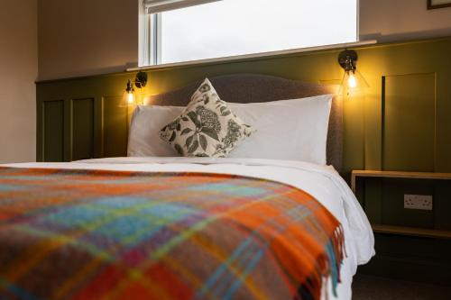 a bed with a colorful blanket and pillows on it at Aiteall Bed and Breakfast in Liscannor