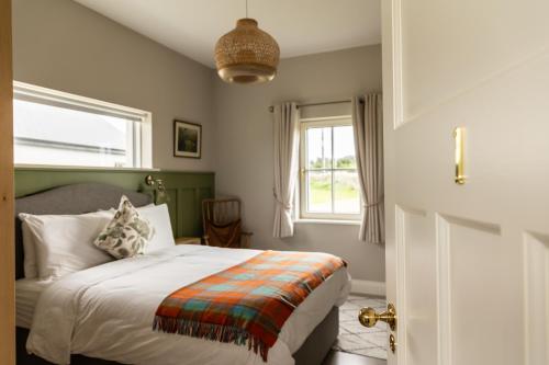 um quarto com uma cama e uma janela em Aiteall Boutique Accommodation em Liscannor