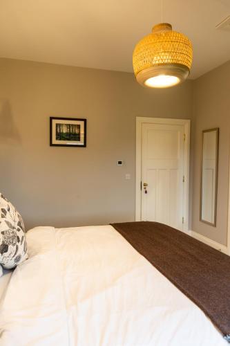 a bedroom with a large white bed and a chandelier at Aiteall Bed and Breakfast in Liscannor