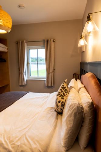 a bedroom with a white bed with a window at Aiteall Bed and Breakfast in Liscannor