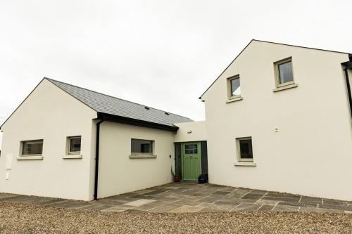 a white building with a green door at Aiteall Bed and Breakfast in Liscannor