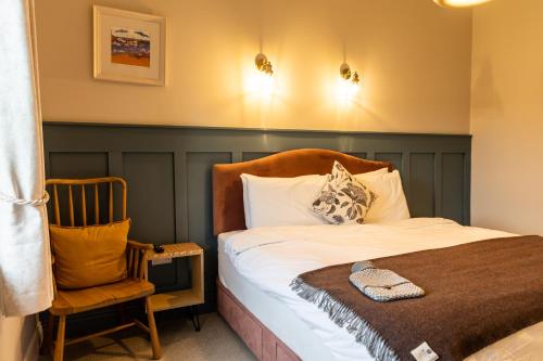 um quarto com uma cama, uma cadeira e luzes em Aiteall Boutique Accommodation em Liscannor