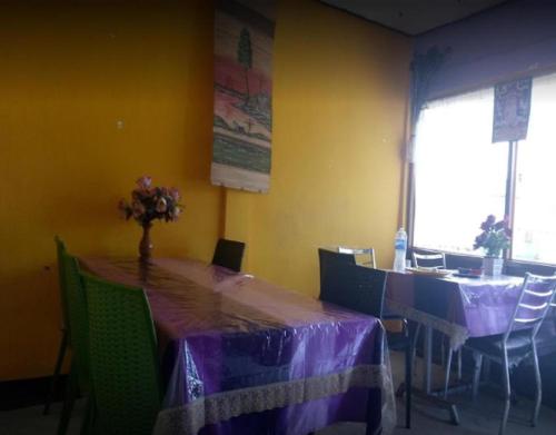 a dining room with a table with purple table cloth at Pulu Lodge & Dining by StayApart in Jorhāt
