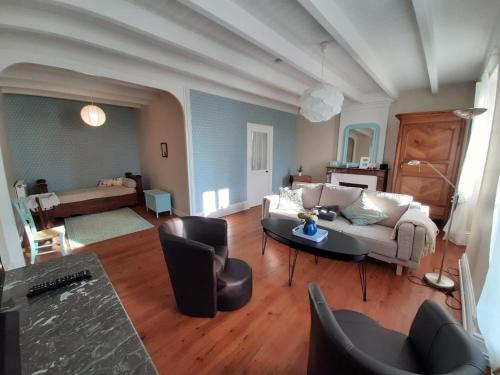 a living room with a couch and a table at Gîte viticole avec jardin clos, terrasse, jeux et visites de distillerie en Charente - FR-1-653-30 in Lignières-Sonneville