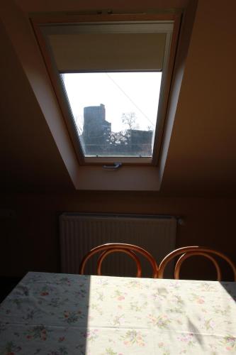 a table and two chairs with a window at Vár-Liget Vendégház in Kisnána