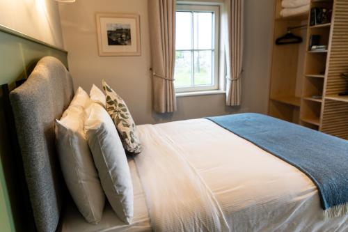 a bedroom with a bed with pillows and a window at Aiteall Bed and Breakfast in Liscannor