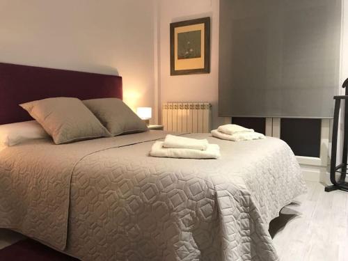 a bedroom with a large bed with towels on it at Albatros (wifi y garaje) in Avila