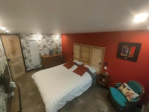a bedroom with a white bed and a red wall at L'Atelier in Saint-Laurent-Blangy