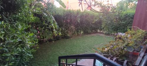 a garden with green plants and a fence at Hotel apartment in Sheikh Zayed City in Sheikh Zayed