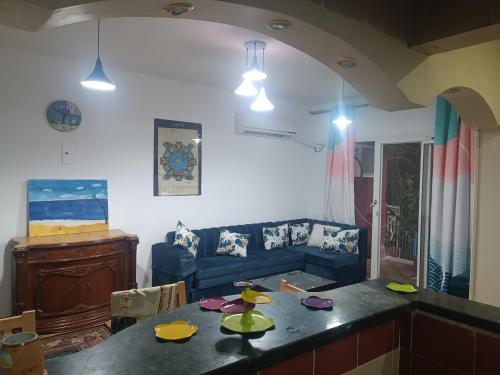 a living room with a blue couch and a table at Hotel apartment in Sheikh Zayed City in Sheikh Zayed