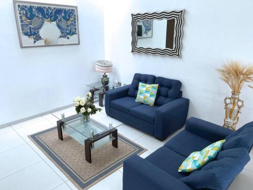 a living room with two blue couches and a table at Amazing House in Aguacalientes with Pool in Aguascalientes