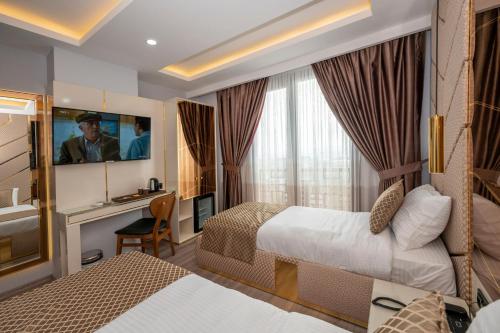 Habitación de hotel con 2 camas y escritorio en Luxury Airport Hotel, en Arnavutköy