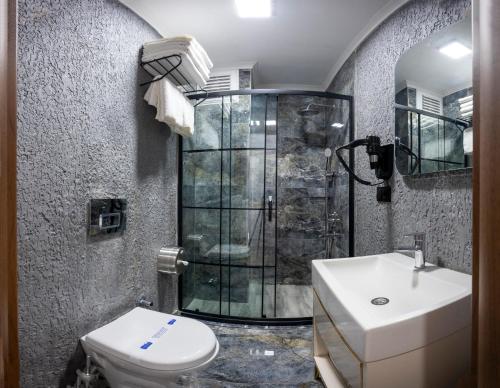 a bathroom with a shower and a toilet and a sink at Luxury Airport Hotel By Zazzoni-İstanbul Airport in Arnavutköy