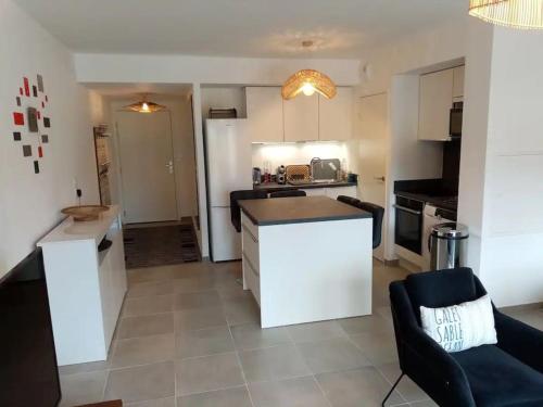 une cuisine et un salon avec un canapé et une table dans l'établissement Sainte Maxime - Superbe appartement neuf classé 4 etoiles, à Sainte-Maxime