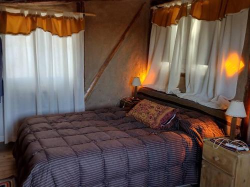 a bedroom with a large bed with white curtains at Hospedaje de Barro in La Consulta