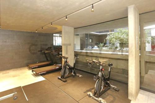un gimnasio con 2 bicicletas estáticas en una habitación en Dpto de 1 dormitorio y 1.5 baños con amenities en Belgrano R Villa Urquiza en Buenos Aires