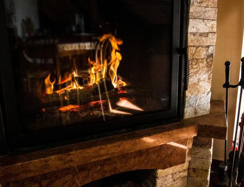 a fireplace with a fire in it at Vár-Liget Vendégház in Kisnána