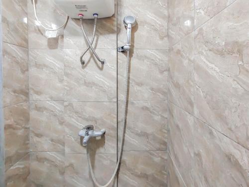 een douche met een slang in de badkamer bij RedLiving Apartemen The Suites Metro - King Property Tower C in Bandung