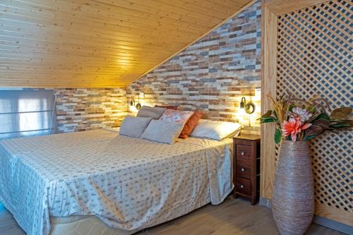 um quarto com uma cama e uma parede de tijolos em Casa Rural La Pinara em La Adrada