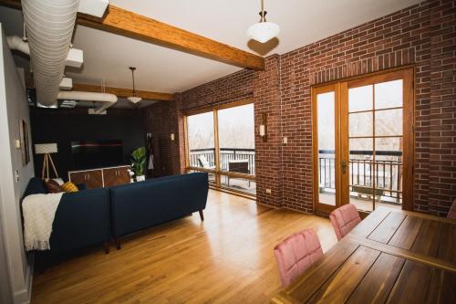a living room with a blue couch and a brick wall at Spacious Loft Over Coffee Shop - Romantic Downtown Escape in Greeley