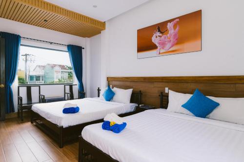 ein Hotelzimmer mit 2 Betten und blauen Kissen in der Unterkunft Hoi An Nguyen Homestay in Hoi An