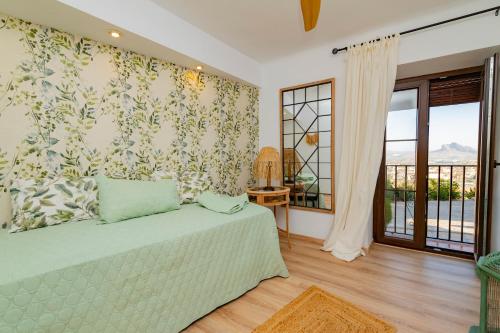 a bedroom with a bed and a large window at Casa Remotti in Antequera