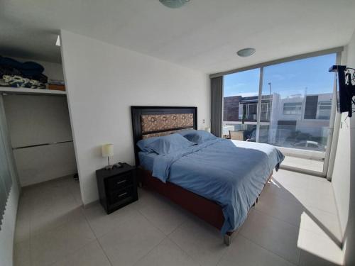 a bedroom with a bed and a large window at Modern House in gated community with green gardens in Aguascalientes