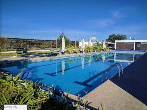 a large swimming pool with blue water at Modern House in gated community with green gardens in Aguascalientes