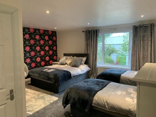 a bedroom with two beds and a window at Roadside House in Ballynahinch